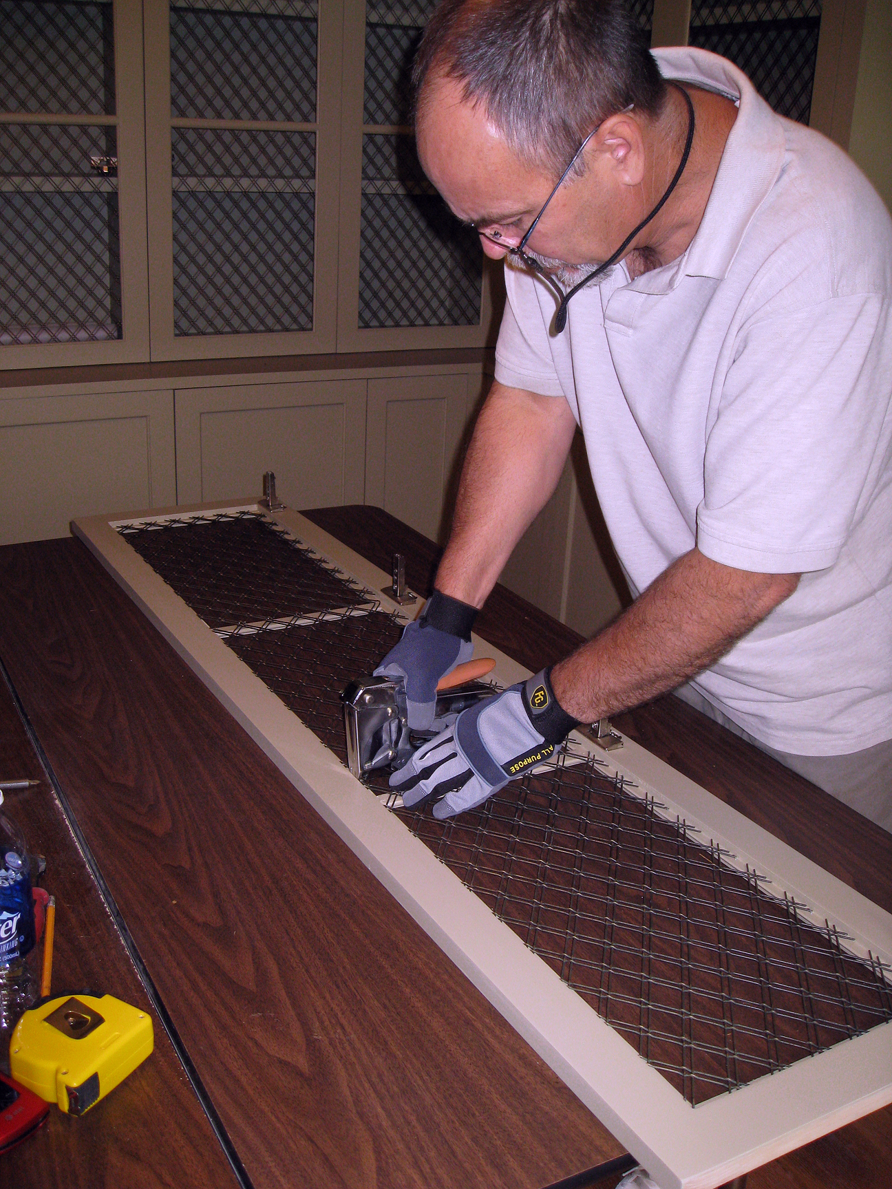 (above) Bert is securing the wire with staples to the inside of the frame on the backside of the cabinet door.