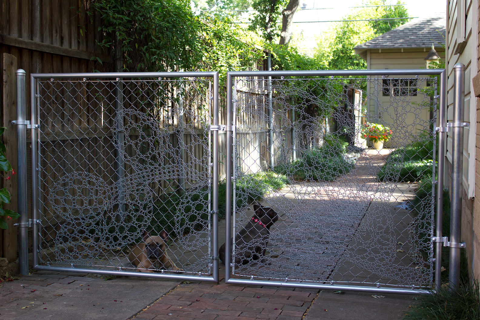 Please click on the photo for a larger version and notice the lacy details of the chain-link fabric. The silver spray paint on the poles around the hinges and fittings will have to be removed. Ggggrrrr...