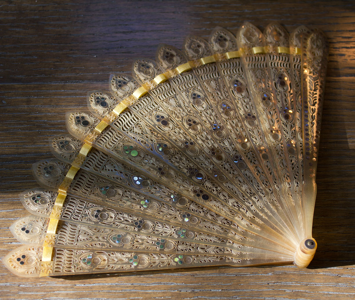 (above) In the seller’s words: “Antique 19th century brisé fan of blond horn intricately pierced with stylized floral motifs and elaborate tracery accented further by numerous steel sequin piqué inlay to the front.”
